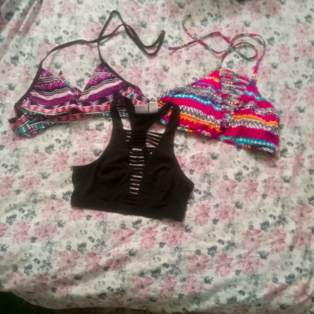 Two bathing suit tops and one sports bra. All different sizes.